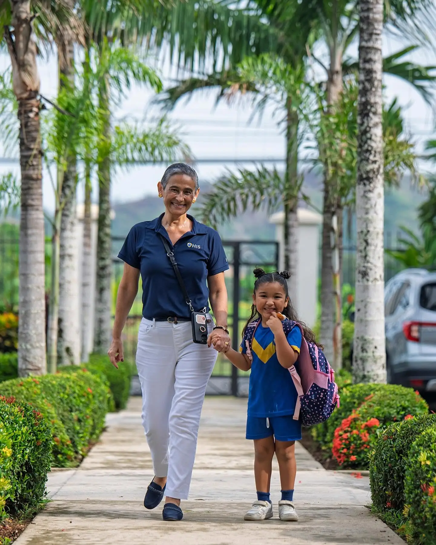 Adult and student walking toward school